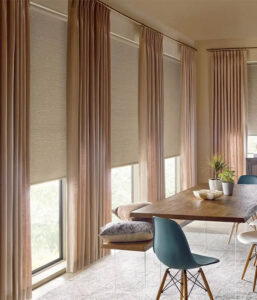 Elegant floor-to-ceiling drapes paired with modern roller window shades in a Miami dining room