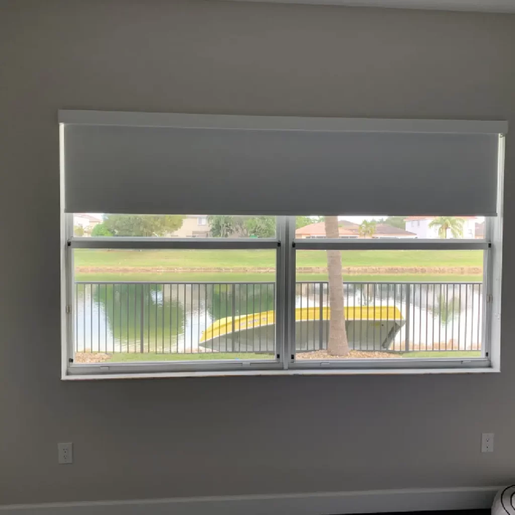 A modern roller shade partially covering a wide window,