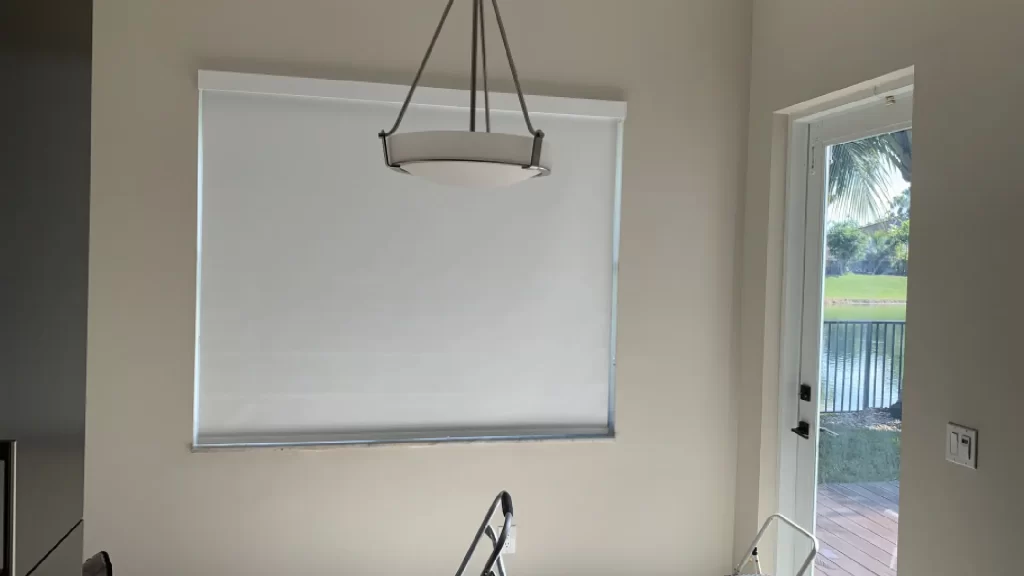White blackout roller shade installed on window in Miami living room