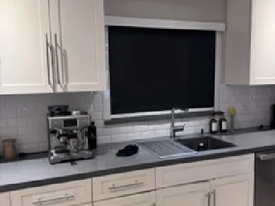 Black blackout shade installed above kitchen sink window in Miami home